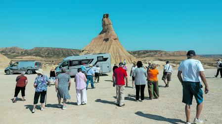 Un grupo de turistas se para a observar Castildetierra durante su excursión en las Bardenas Reales