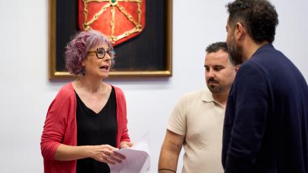 La consejera Rebeca Esnaola habla con los socialistas Ramón Alzórriz y Carlos Mena, antes del comienzo de su comparecencia parlamentaria.