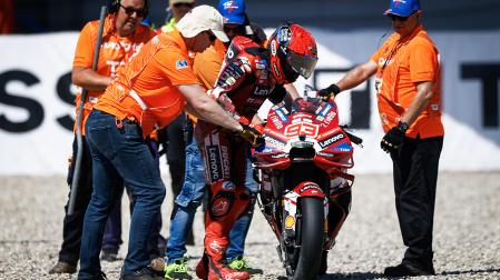 Marc Márquez es ayudado por el personal de Assen a subir a su moto tras sufrir una caída este viernes 26 de junio