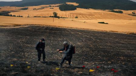 Agentes de la Policía Foral trabajan en el lugar donde empezó el fuego, un campo de cereal sin cosechar entre Makirriain y Orrio