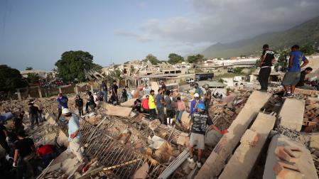 Personas realizan labores de búsqueda en una zona afectada por un terremoto, este viernes en La Guaira (Venezuela).