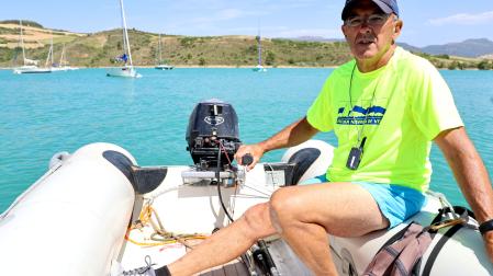 Ángel González, en la zodiac con embarcaciones al fondo en el pantano de Alloz.