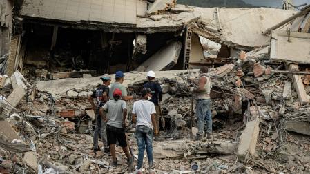 Personas participan en labores de búsqueda en un edificio afectado por un terremoto, este sábado en La Guaira (Venezuela).