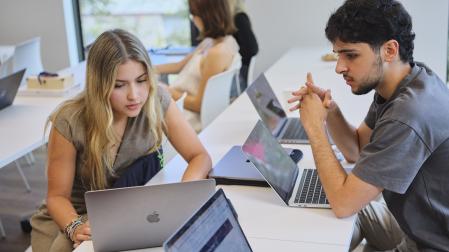 Dos universitarios trabajan en el aula