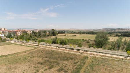 Vista de parte de los terrenos donde se desarrollará el nuevo barrio, con la carretera hacia Fontellas en el centro