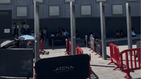 La gente esperando a que abran las puertas refugiándose del sol bajo paraguas y el porche del Navarra Arena