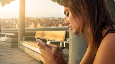 Una joven, con su teléfono móvil