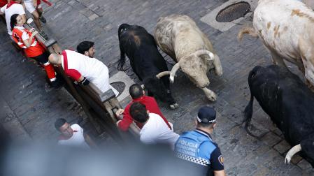 Fotos del primer encierro de San Fermín a su paso por la plaza del Ayuntamiento.