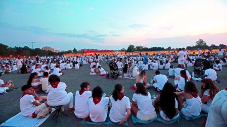 Cuadrillas y familias esperan sentados sobre toallas y bolsas de basura a que empiecen los fuegos artificiales