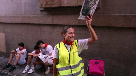 A: EDUARDO BUXENS F: 09 JULIO 2026 L: PAMPLONA , SANTO DOMINGO T:AMBIENTE PRE-ENCIERRO DÍA 9, SANTO DOMINGO - venta y lectura de prensa escrita en la cuesta de Santo Domingo momentos antes del encierro