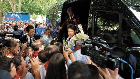 Un grupo de niños recibiendo ayer al diestro Andrés Roca Rey en su llegada junto a su cuadrilla a la plaza de toros pamplonesa