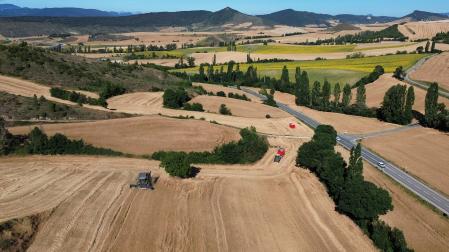 Vista tomada con un dron de una cosechadora en un campo de trigo en el valle de Unciti