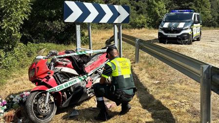 Un agente de la Guardia Civil junto a la motocicleta accidentada