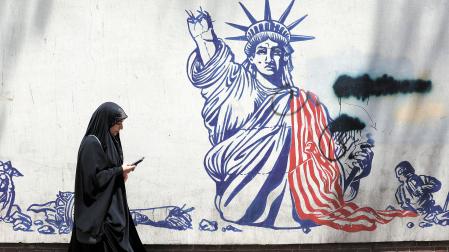 Una mujer pasa delante de una pintada antinorteamericana en el edificio donde estuvo la embajada de EE UU en Teherán