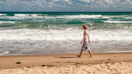 Una mujer da un paseo por la playa