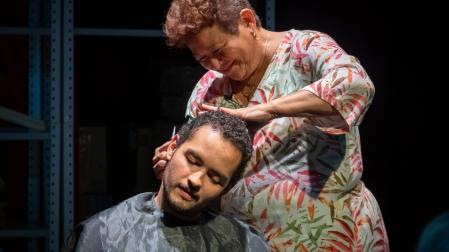 Josefina Orlaineta corta el pelo a su hijo, Anacarsis Ramos, en 'Mi madre y el dinero', obra en la que reproducen algunos de los cuarenta trabajos que ha tenido ella, como este de peluquera