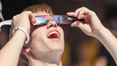 Un joven se coloca unas gafas de sol para disfrutar del eclipse de sol total
