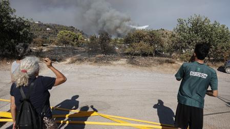 Varias personas observan la pelea contra las llamas en el incendio de La Vall d'Uixò (Castellón)