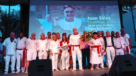 Juan Sáinz, sosteniendo un ramo de flores, junto a anteriores Tudelanos Populares durante su homenaje en el paseo del Queiles