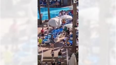 Los turistas celebrando conseguir la hamaca en la piscina del hotel