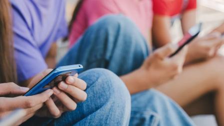Varios jóvenes con sus móviles