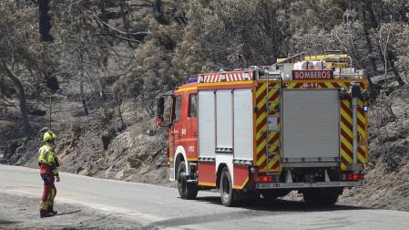 Un camión de bomberos trabaja en la superficie arrasada en Casavieja (Ávila)