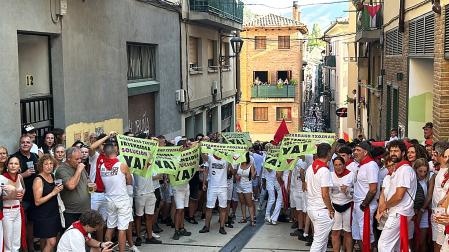 varias personas sujetan pancartas de protesta por las txoznas este viernes, 31 de julio, en Estella