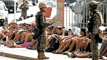 Militares españoles vigilan a migrantes antes de escoltarles en su regreso a Marruecos