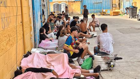 Varias decenas de migrantes descansan en una calle de Ceuta tras los cruces masivos a pie y por mar desde Marruecos