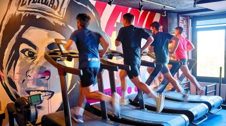 Deportistas corren en la cinta al ser la parte de cardio correspondiente a ese entreno en el gimnasio Onfitness.