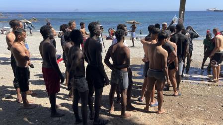 Los jóvenes inmigrantes que duermen en la calle hacen cola para ducharse en la playa del Trampolín, tras acceder a Ceuta el pasado jueves durante la entrada masiva por el espigón fronterizo protagonizada por más de 70.000 personas y que permanecen en la ciudad, entre ellos 528 menores