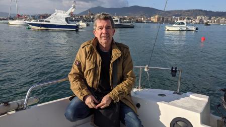 Alfredo Piedrafita sonríe subido a un barco en la bahía de Txingudi, entre Hendaya, Hondarribia e Irún.