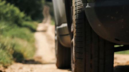 Un vehículo circula por un camino rural