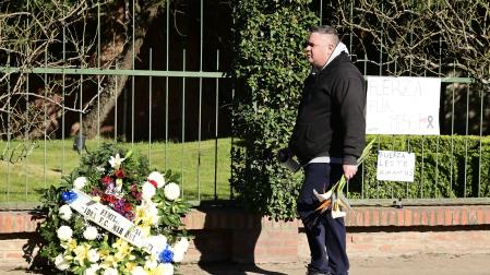 Una persona camina llevando un ramo de flores frente al cementerio privado El Prado, este domingo en Rosario (Argentina)