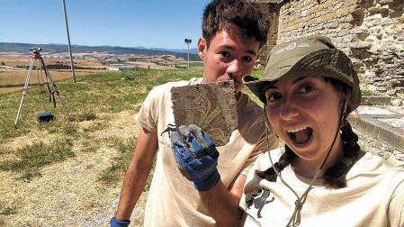 Momento del descubrimiento de uno de los azulejos decorados vidriados, exhumados en la excavación del palacio por Paula Albero y Miguel Apesteguía.