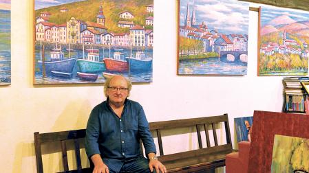 El pintor Juan Carlos PIkabea posando junto a sus cuadros en su casa en Lesaka