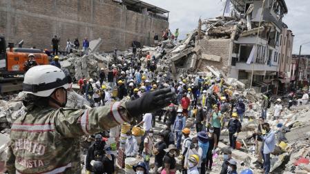 Una rescatista del Ejercito de Colombia da indicaciones a un grupo de voluntarios que realiza labores de búsqueda en edificaciones destruidas por el terremoto de magnitud 7,4 del pasado lunes, este miércoles en Pereira (Colombia)