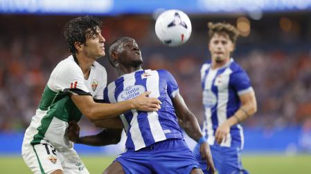 El centrocampista camerunés del Deportivo Nsongo Bil disputa un balón con Gonzalo Villar, del Elche