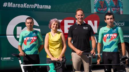 Los ciclistas Ibon Ruiz y Diego Uriarte flanquean, delante del autobús del equipo, a Rebeca Esnaola (consejera del Gobierno de Navarra) y a Juanjo Oroz (mánager general del Kern Pharma).