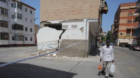 Un hombre pasa este jueves junto a una vivienda con desperfectos causados por los terremotos de los días anteriores en Granada