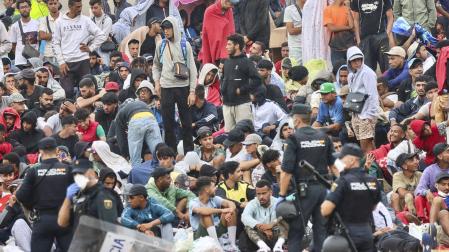 La policía vigila a inmigrantes que continúan viviendo en las inmediaciones de la playa del Trampolín en Ceuta, este viernes