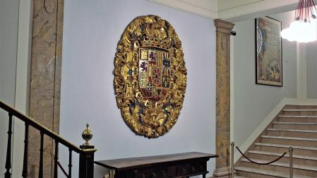 El escudo de armas reales, tallado en madera en 1735, en el zaguán de la casa consistorial de Pamplona
