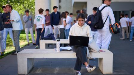 Una joven utiliza su ordenador en el campus de la Universidad de Navarra