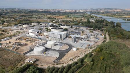 Imagen de la depuradora de aguas residuales de Tudela, con el casco urbano de la ciudad al fondo, y el cauce del río Ebro a la derecha