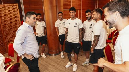 Braulio Vázquez saluda a los futbolistas del Valencia en Vitoria