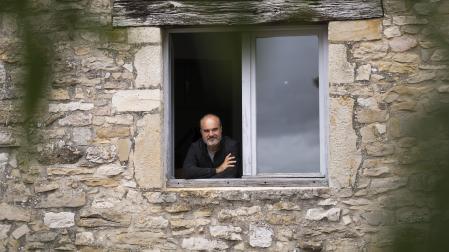 Oskar Alegria se asoma a la ventana del dormitorio de Jorge Oteiza en Alzuza, desde la que el escultor veía el fresno (en primer plano) sobre el que escribió