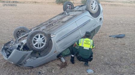 Un agente de la Guardia Civil revisa el estado del vehículo que ha volcado en Olite