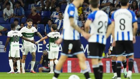 Los jugadores del Elche celebran uno de los dos goles de Fer Niño jugando con uno menos ante la incredulidad de los futbolistas del Espanyol