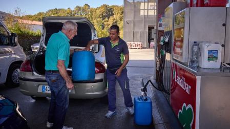Un ciudadano francés rellena garrafas con gasóleo tras llenar el depósito de su coche en Dantxarinea