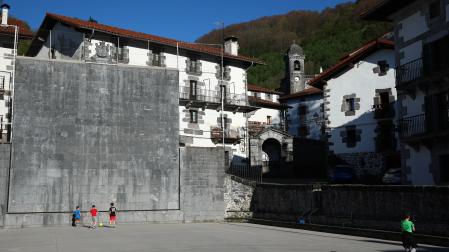 Un grupo de menores juega en el frontón de la plaza de Leitza.
